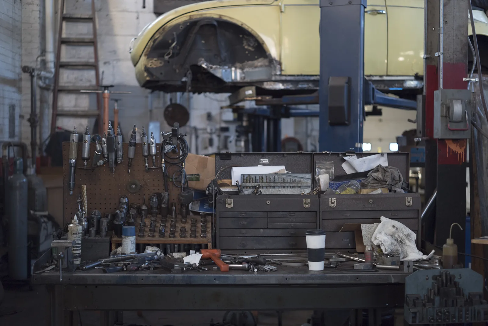 A classic-car workshop bench with tools and components